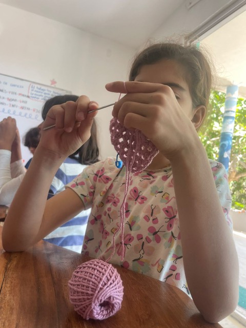 Niña tejiendo con gancho