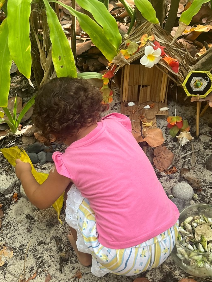 Niña junto a una casita de hadas en el jardín