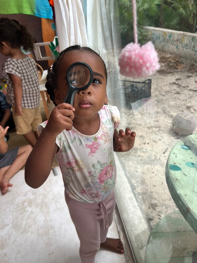 Niña observando con una lupa