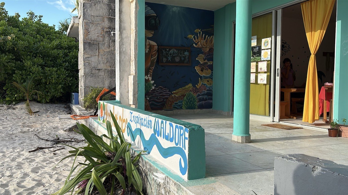 Entrada de Yoolo'ob en la playa, con el mural «Inspiración Waldorf»